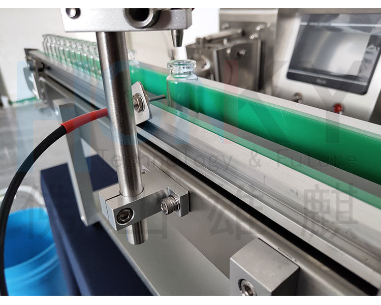 ডেস্কটপ 5 মিলি ভলিউম ফিলিং মেশিন ছোট ফিলিং লাইন বোতল খাওয়ানোর কনভেয়র এবং সামিল বাখের সাথে কসমেটিক তেল ফিলিংয়ের জন্য